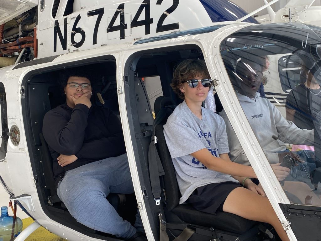 Students seated in a helicopter during an aerospace learning experience