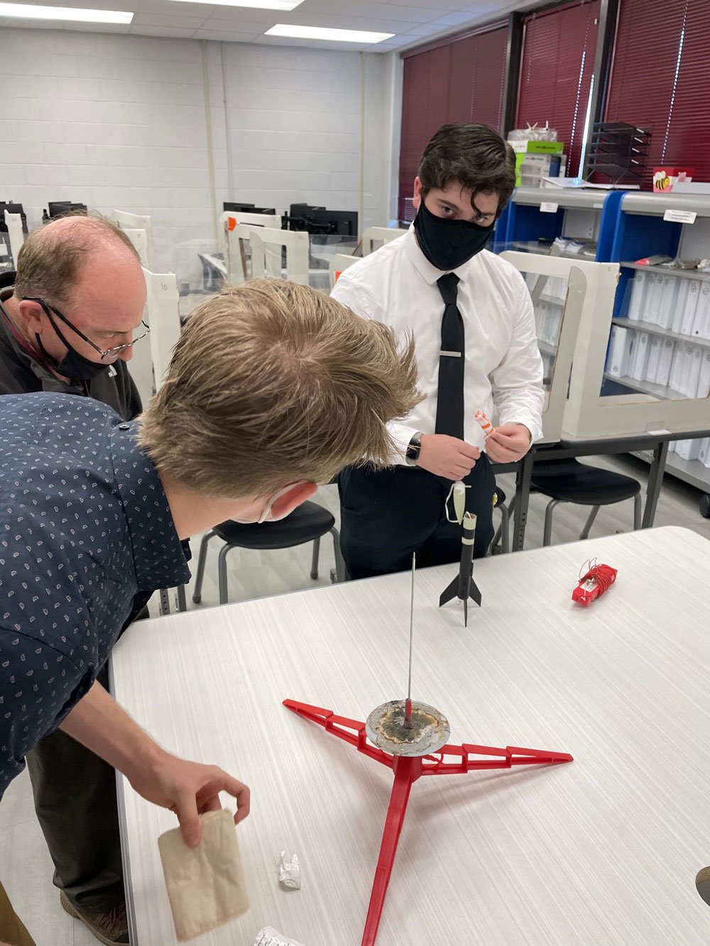 Aerospace students preparing a model rocket for launch